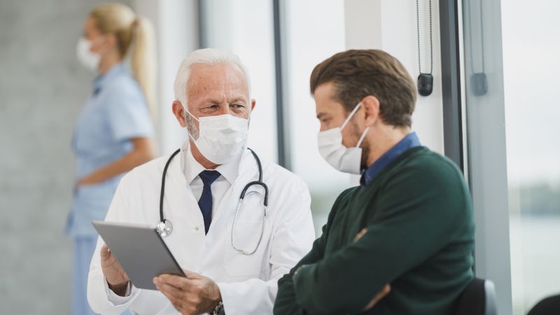 Médico revisando información con un paciente